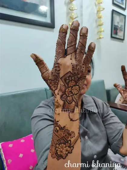 A beautiful designer mehendi for the back of the hand. This piece combines floral elements with geometric shapes for a truly unique and artistic look.