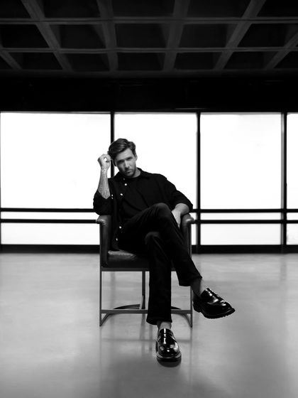 A moody black and white portrait for a Moral Code campaign. The minimalist setting and dramatic lighting create a sophisticated and high-end feel for the brand.