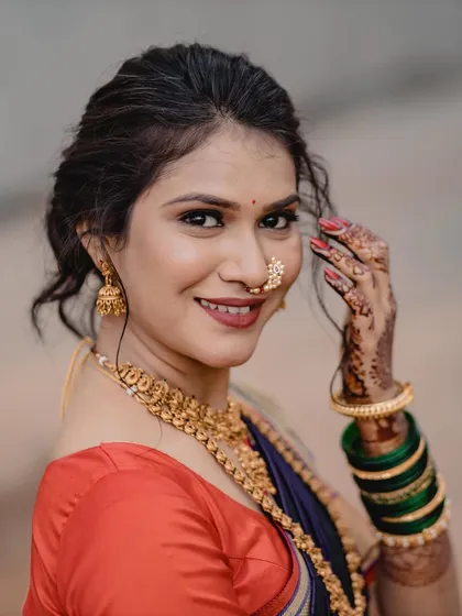 A happy and natural portrait from an engagement shoot. The soft, outdoor light beautifully captures the fresh makeup and the simple, elegant styling of her hair and saree.
