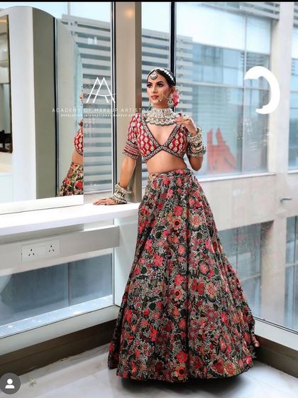 The full view of the floral lehenga, showing its beautiful A-line cut and the contrast with the red embroidered blouse.