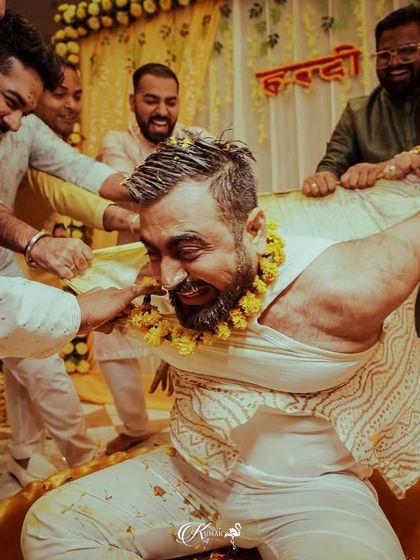 The groom's friends playfully tear his kurta during a wild and fun-filled haldi ceremony.
