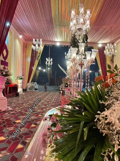 A view from the side of a grand entrance, showing the layers of decor from floral arrangements to candelabras and chandeliers.