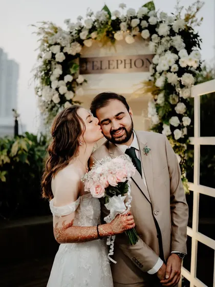 A sweet moment captured at the floral-draped telephone booth.