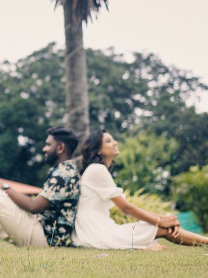 A soft-focus, dreamy shot of a couple relaxing on the grass, capturing a quiet, peaceful moment from their post-wedding shoot.