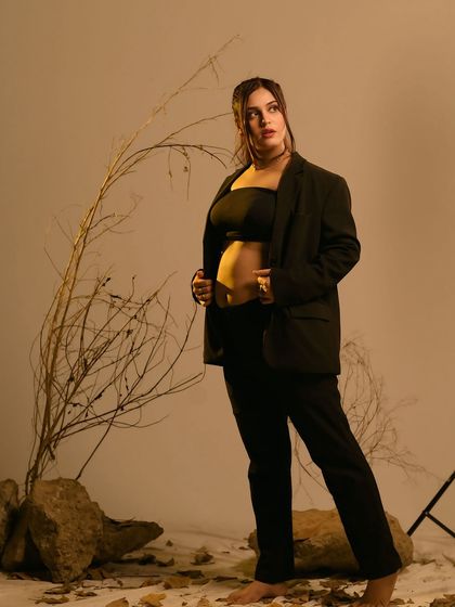 A bold and confident pose. This studio shot, with its earthy tones and minimalist props, showcases a modern and empowered vision of the mother-to-be.