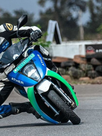 A rider on an Ather scooter shows incredible lean angle, pushing the limits of what electric two-wheelers can do on a racetrack.