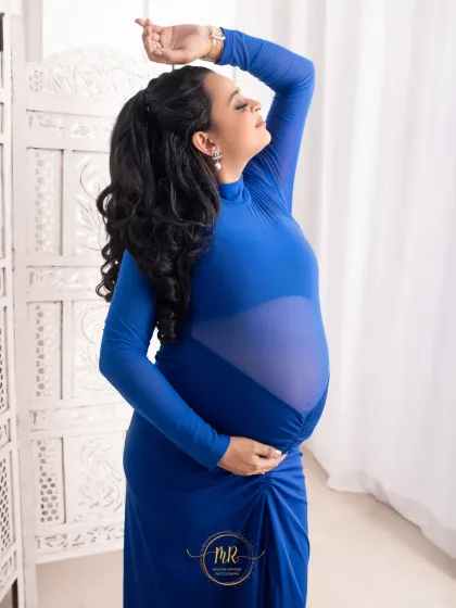 A powerful pose in a modern royal blue gown. The mother-to-be's pose is strong and graceful, highlighting her silhouette against a simple, elegant background.