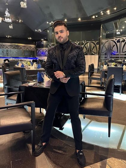 Another view of the client in the all-black sequin tuxedo, highlighting its shimmer and modern design.