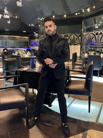 Another view of the client in the all-black sequin tuxedo, highlighting its shimmer and modern design.