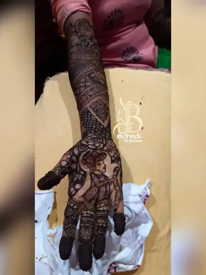 The groom's portrait, perfectly rendered in henna to complete the couple's story on the bride's hands.
