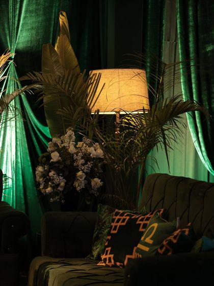 A close-up of the custom-designed zodiac cushions on a plush green velvet sofa. This small detail was a nod to the couple's story and added a layer of personalization to the decor.