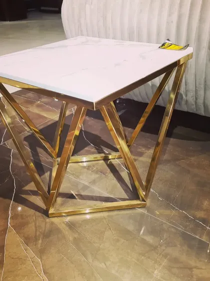 Similar to the amethyst version, this corner table has a white marble top. The geometric gold-finished base adds a modern, luxurious touch to any room.