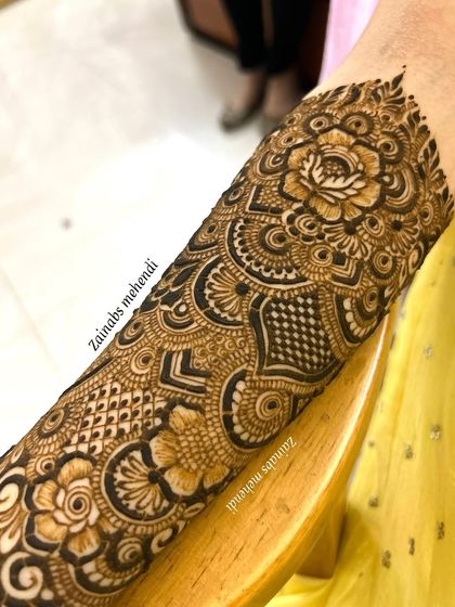 A detailed shot of the upper portion of Momina's bridal henna, featuring a large rose and intricate surrounding patterns.