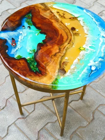 This side table is a perfect example of a complete miniature world. It features a sandy beach, a flowing river, and a deep blue ocean section, all within a single piece of wood.
