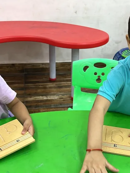 In our toddler classes, we use Montessori-inspired activities like these wooden number tracing boards to make learning hands-on and fun.
