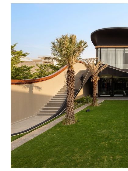 A sculpted external staircase at Residence Ondra provides direct access to the upper-level party lounge. This feature allows for seamless entertaining, guiding guests upward along a gracefully curving wall that integrates with the landscape.