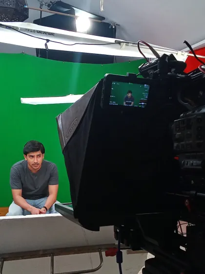 A behind the scenes look at a studio shoot, showing a green screen setup. This technique allows for complete creative freedom in post-production, enabling us to build any world your music imagines.