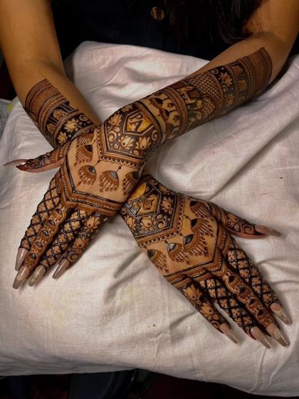 This photo highlights the full coverage of our back-hand bridal mehandi. The design extends from the fingertips to the elbows, creating a complete and stunning look.
