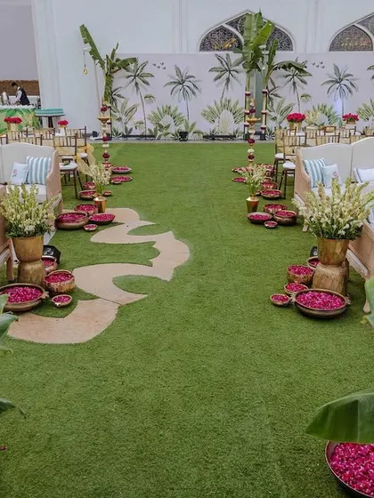 A unique aisle design for the Taj Palace wedding, with a meandering path cut into the turf and lined with bowls of rose petals. This created a more organic and visually interesting walkway for the guests.