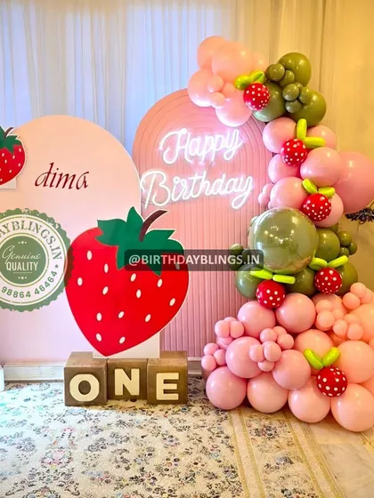 Another view of the strawberry first birthday, showing the light-up number '1' and personalized backdrop.
