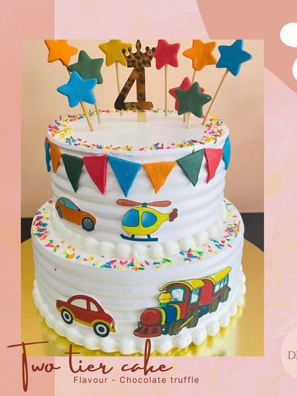 A colorful two-tier transport-themed cake for a child's birthday. Featuring fondant cars, a helicopter, and a train, it's a playful design for any young vehicle enthusiast.
