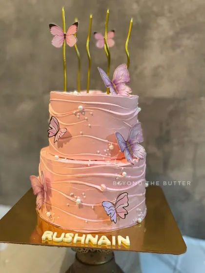 This two tier butterfly themed cake is all about elegance and charm. I decorated it with delicate, fluttering butterflies, soft pink buttercream waves, and subtle pearl details, making it a beautiful centerpiece for a special birthday.