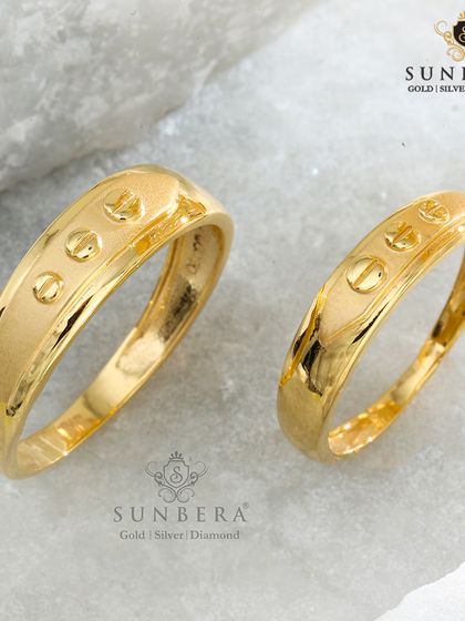 This modern couple ring set features a unique screw-head motif evenly spaced around the band. It's a contemporary and stylish choice for couples who want a design that is both unconventional and symbolic of building a life together.
