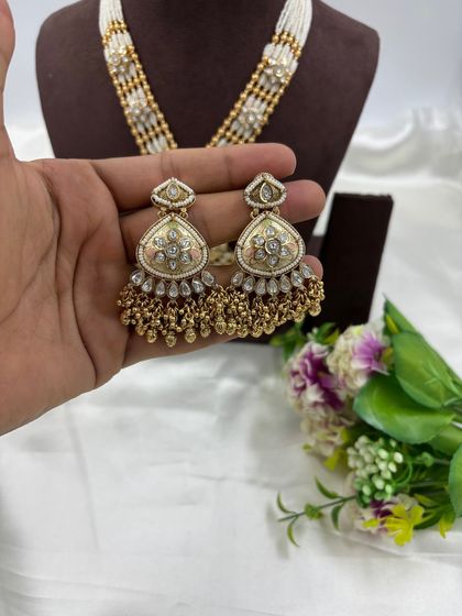 Our "Indira" premium antique gold necklace set. This long necklace features a large, intricately designed pendant with Meenakari work and comes with matching statement earrings.