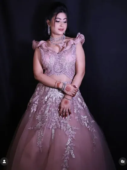 A full-length shot of the dusty pink engagement gown against a black background, emphasizing its elegant and dreamy quality.