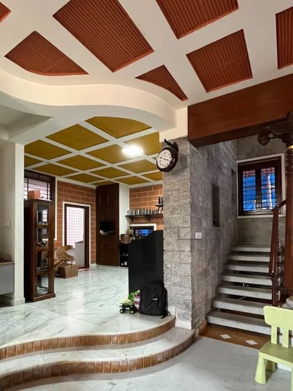 An interior showing a split-level design, with a mix of marble and brick steps, and ceilings with both yellow and red terracotta tiles.