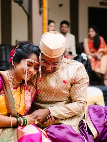 A tender moment between the bride and groom during their wedding rituals, filled with smiles and a gentle touch.