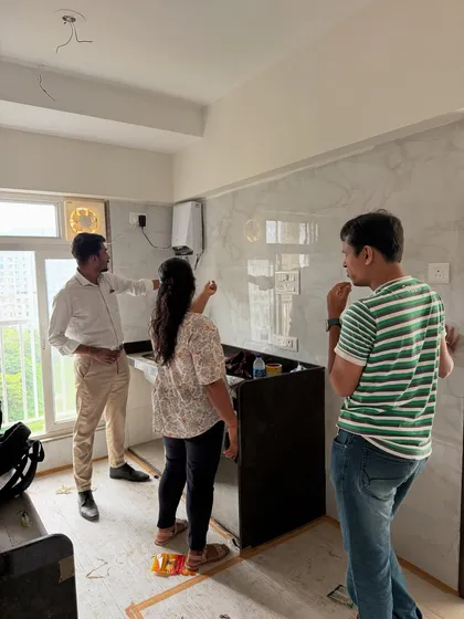 Clients inspecting the newly installed kitchen backsplash tiles while the rest of the area is still under construction.