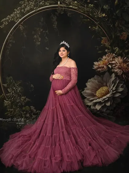 A fairytale portrait with a floral hoop. The mom-to-be, wearing a tiara and a beautiful mauve gown, looks like she stepped out of a storybook.