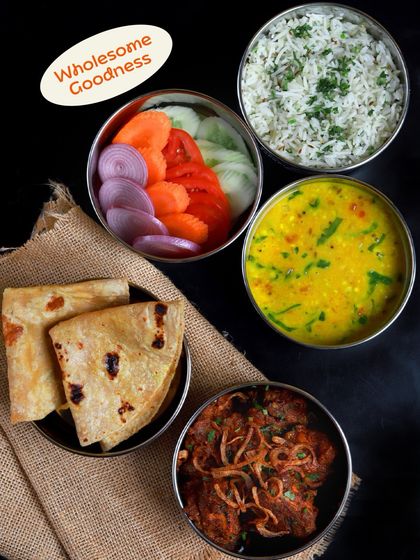Wholesome goodness in every bite. This non-veg meal includes a hearty meat curry, dal, rice, salad, and soft rotis, all packed and ready for your lunch.