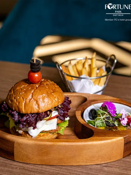 Our gourmet burger is a complete meal, served with a side salad and a basket of golden French fries.