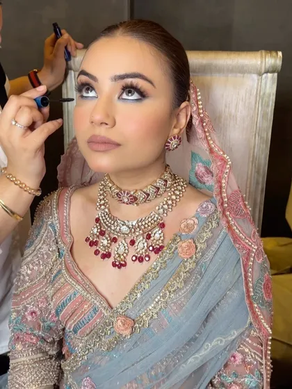 A stunning shot of the bride during her makeup session, with her hair prepped for a sleek updo.