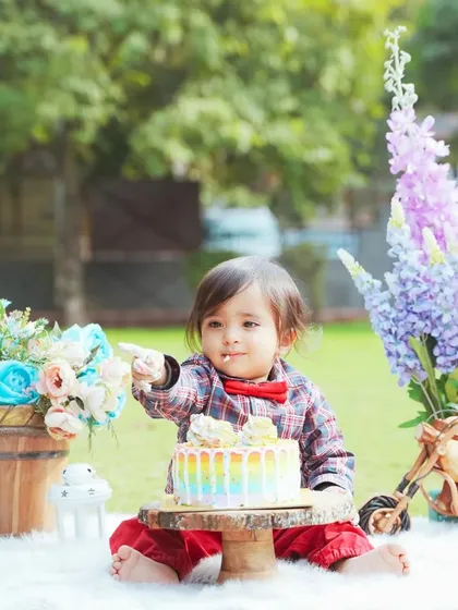 An outdoor cake smash is a great option for a different look. This little one is celebrating his birthday with a colorful cake in a beautiful park setting.