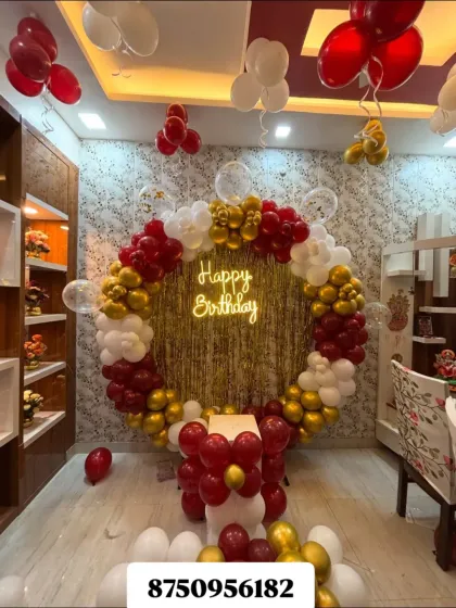 A classic birthday celebration setup perfect for any home party. This features a full circular balloon arch in red, gold, and white, a shimmering backdrop, and a bright "Happy Birthday" neon sign to create a festive focal point.