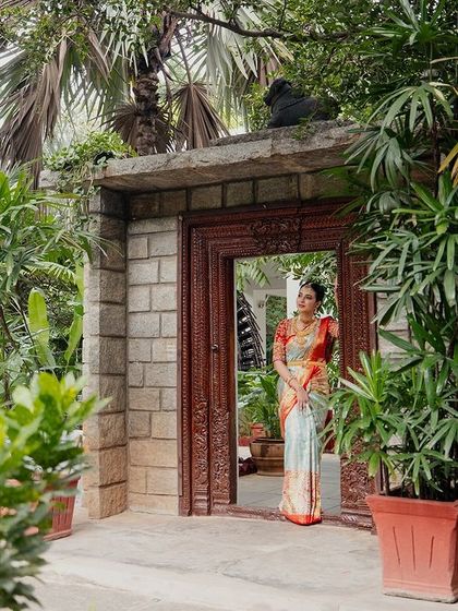 A bride makes her entrance through a stone gateway, surrounded by a profusion of plants. A perfect shot to capture the beginning of the celebration.