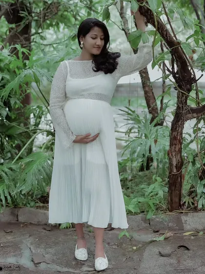Capturing the serene glow of motherhood. This solo maternity portrait uses soft, natural light in a garden setting to create a timeless and elegant feel.