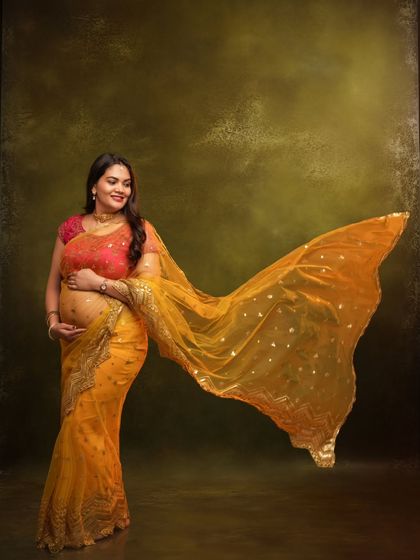A joyful and dynamic shot of the mom-to-be, with her yellow dupatta flowing in the air.