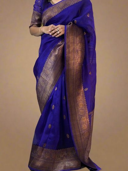 A stunning royal blue pure Kora organza saree with an antique zari border, draped elegantly.