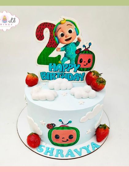 A cute and simple Cocomelon cake for Shravya's 2nd birthday, decorated with fresh strawberries and character cutouts.