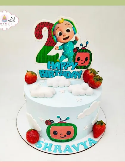 A cute and simple Cocomelon cake for Shravya's 2nd birthday, decorated with fresh strawberries and character cutouts.