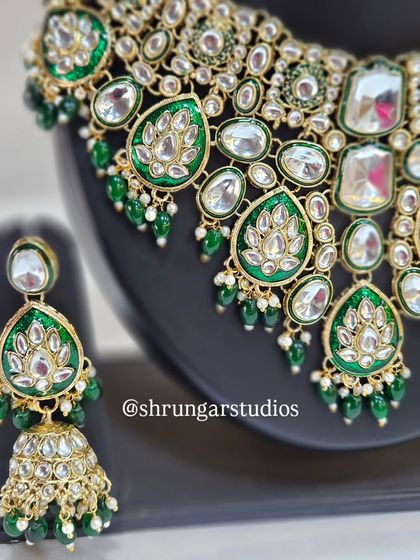 A close-up of the necklace showing the beautiful lotus motifs within the green enamel.