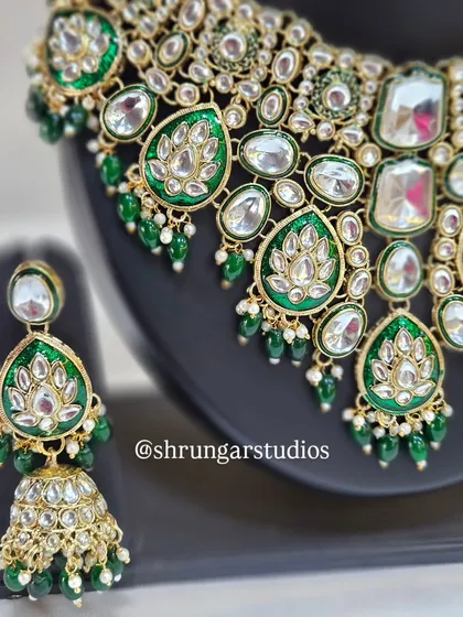 A close-up of the necklace showing the beautiful lotus motifs within the green enamel.