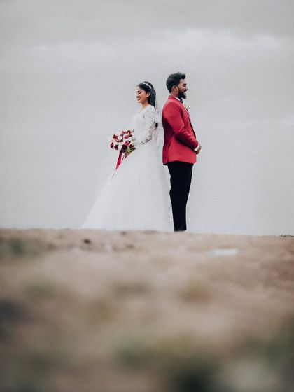 An artistic shot of the couple standing back-to-back on a sand dune. This creative composition tells a story and creates a memorable image.