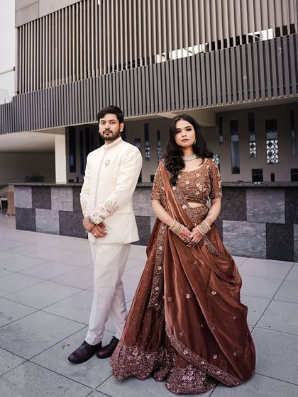A formal, full-length portrait of the engaged couple in their stunning outfits.