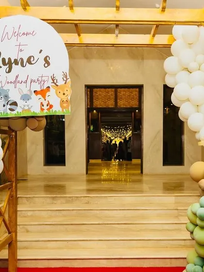 The welcoming entrance to Ryne's woodland party. A custom sign, flanked by balloon arrangements and a cute deer cutout, invites guests to step into an enchanted world.