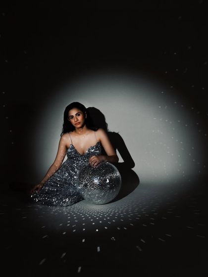 A portrait from a birthday celebration shoot, with the subject seated with a disco ball. It’s a fun, glamorous way to mark a milestone.